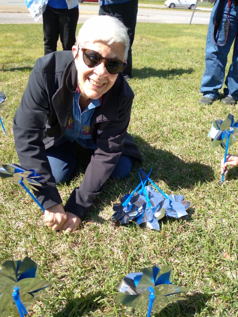 Linda B. installing pinwheels for Child Abuse Awareness & Prevention.