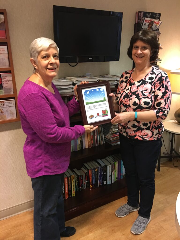 Linda B. and Carol at the "lending library" WCOM established at the Cancer Center at LMC.