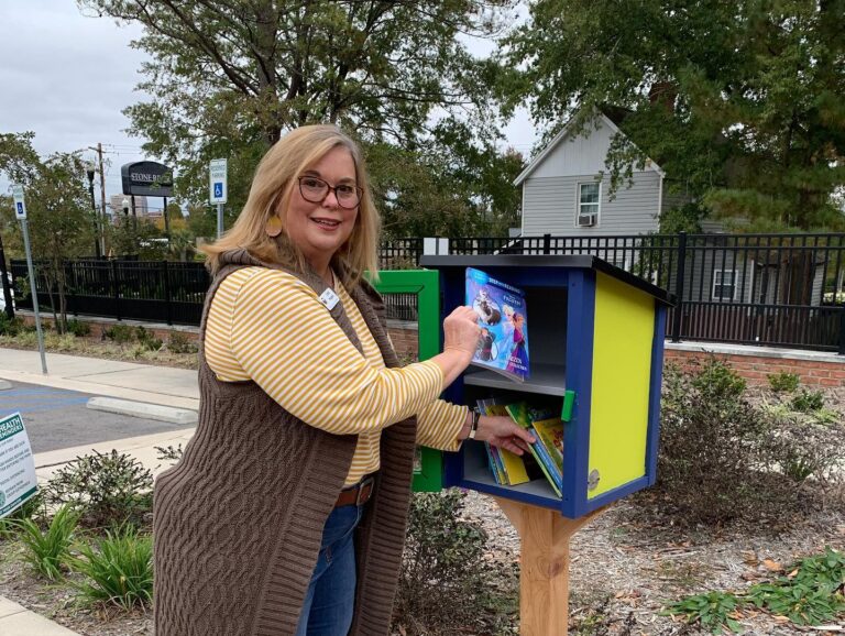 Linda W. checking out the Little Free Library that WCOM donated.